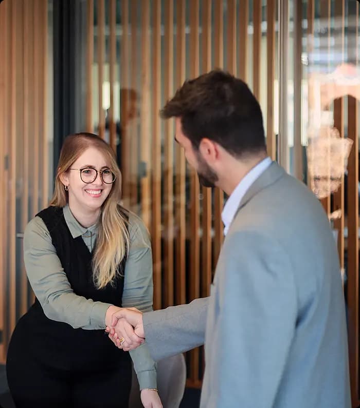 a consultant greets a client with an handshake in the Lisbon office of Portugal Homes